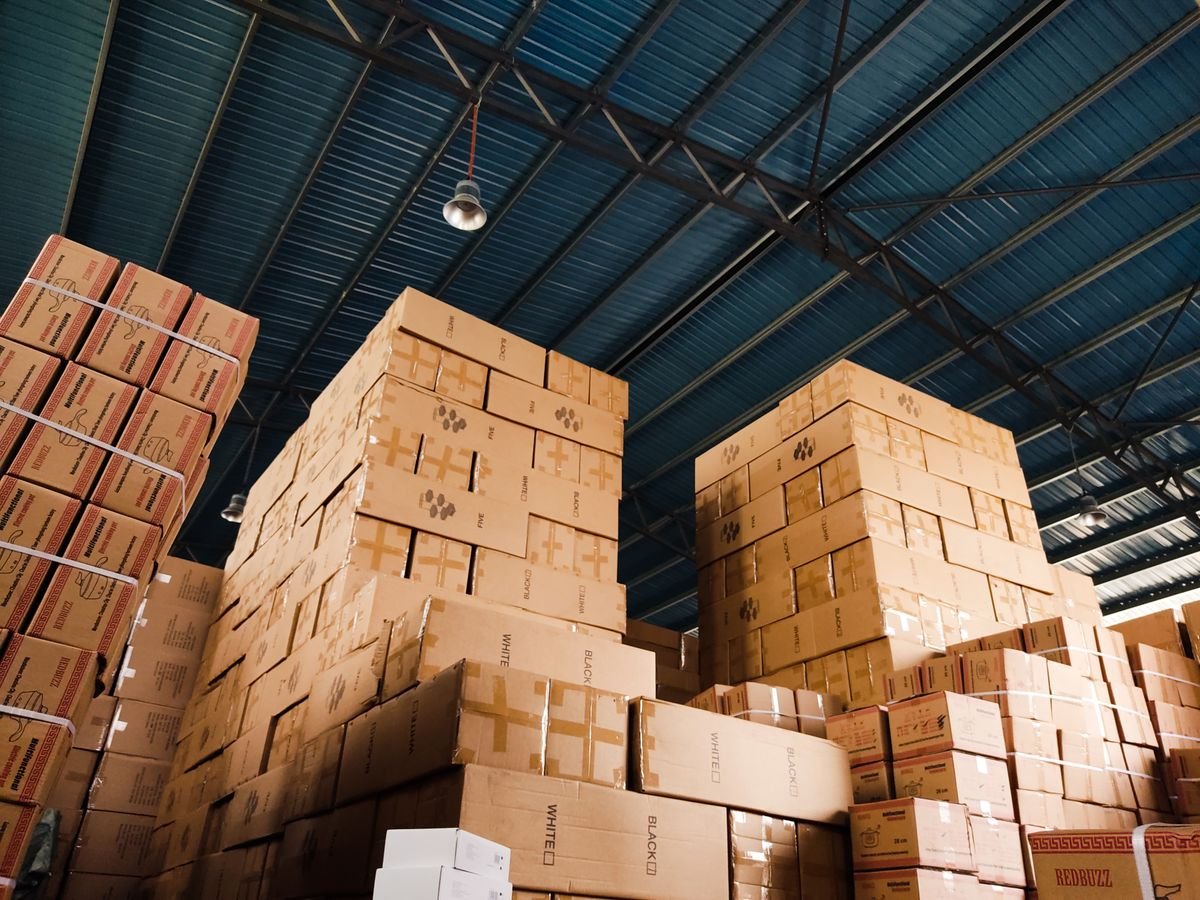 Pilhas altas de caixas de cartão num armazém de distribuição de encomendas
