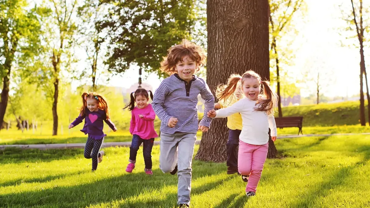 Família com crianças a passear num parque num dia de sol, exemplo da calculadora de abono de família