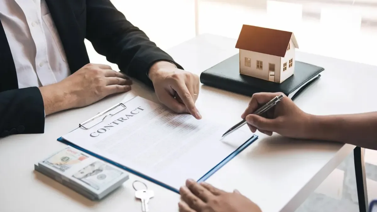 Assinatura do contrato de venda de uma casa com chaves sobre a mesa, exemplo da calculadora de mais-valias