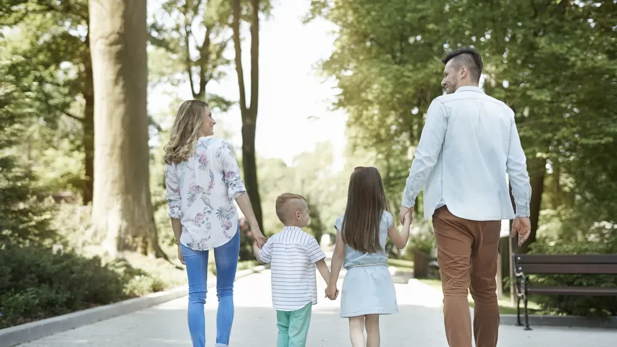 Família a passear num parque com as crianças num dia de sol, ferramentas de apoios e família