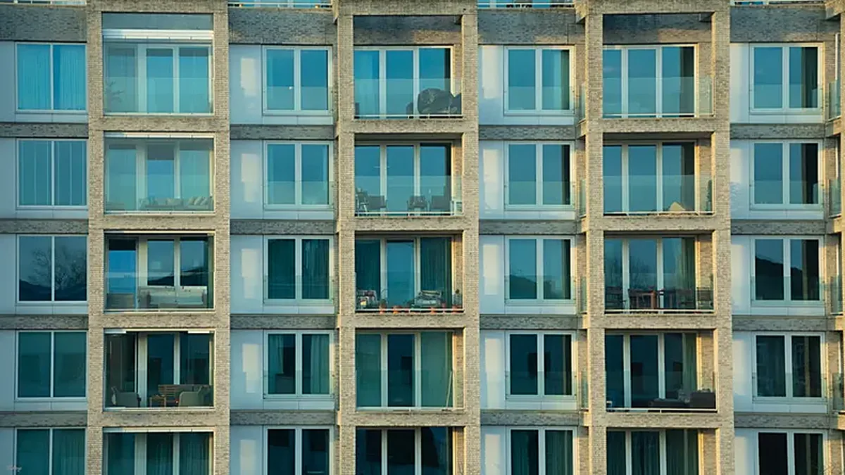 Fachada de prédio de apartamentos numa cidade, exemplo da comparação comprar vs arrendar