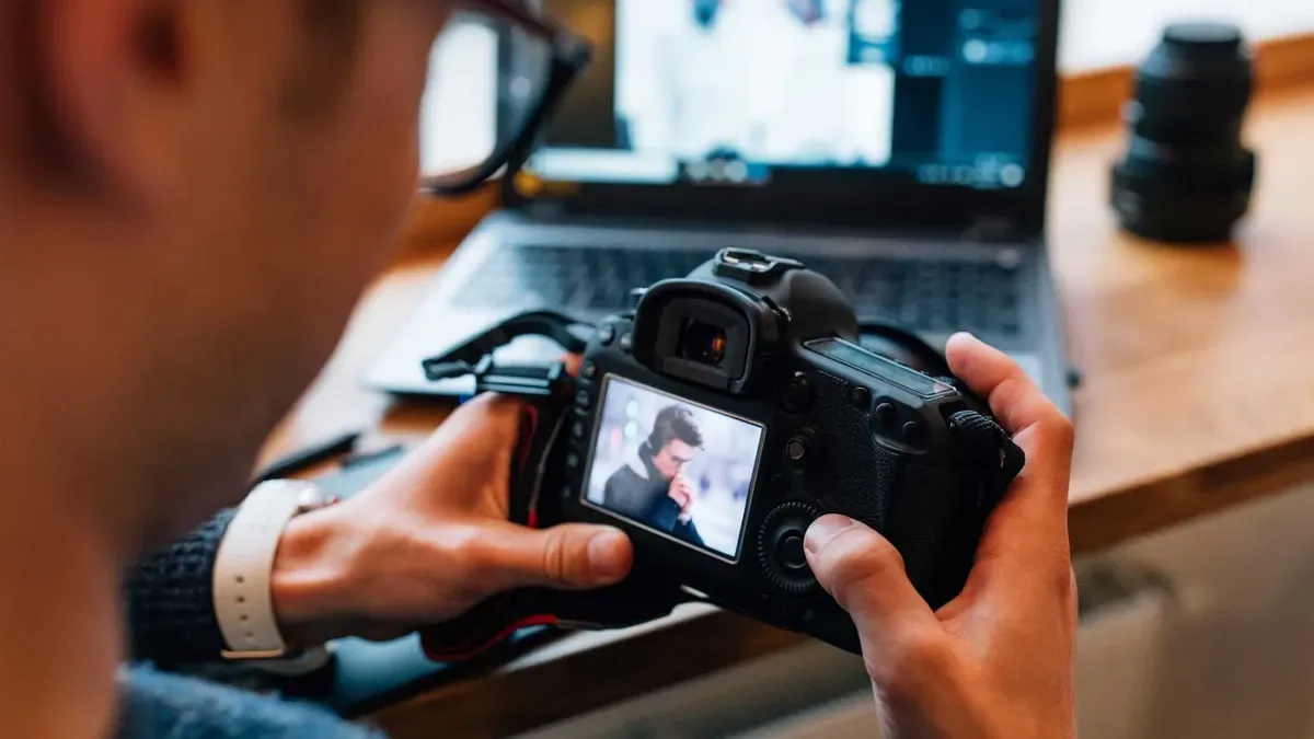 Fotógrafo a rever e editar fotografias num computador, exemplo da ferramenta comprimir imagem