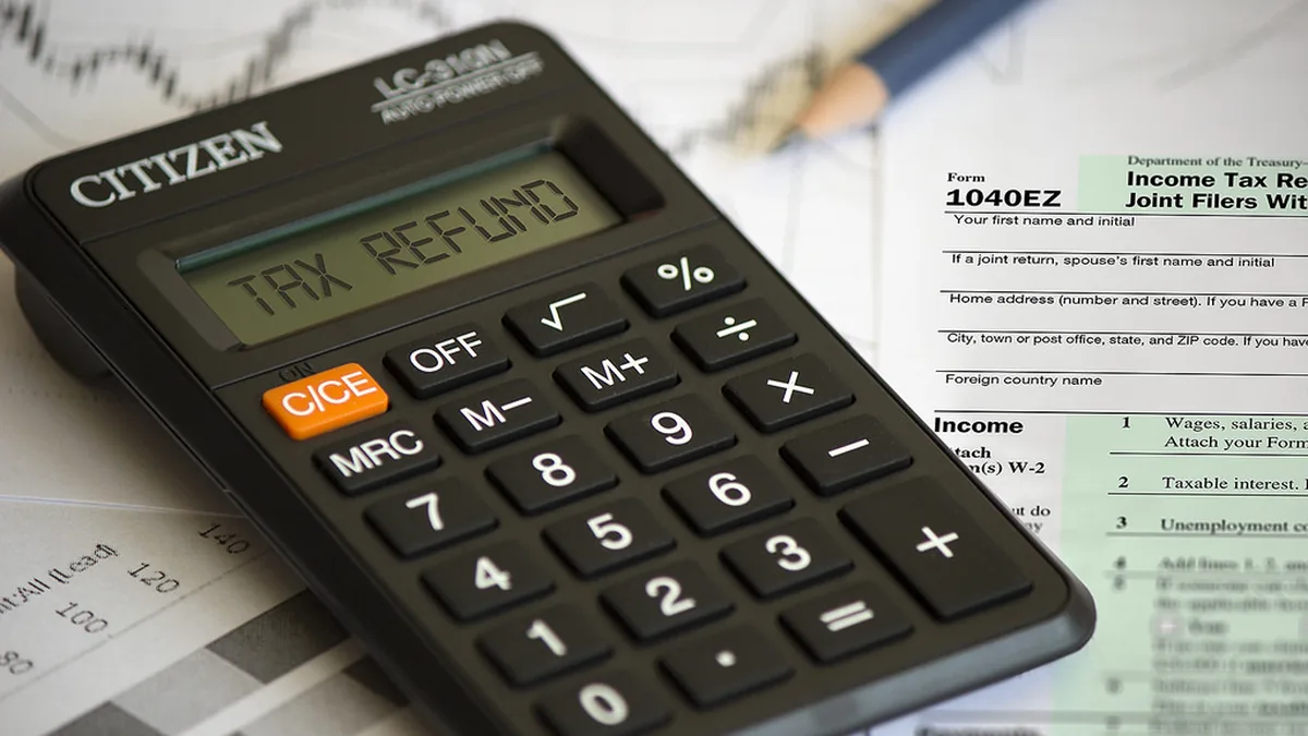 Carta de reembolso e declaração de IRS sobre a mesa com uma calculadora, exemplo da estimativa de reembolso de IRS